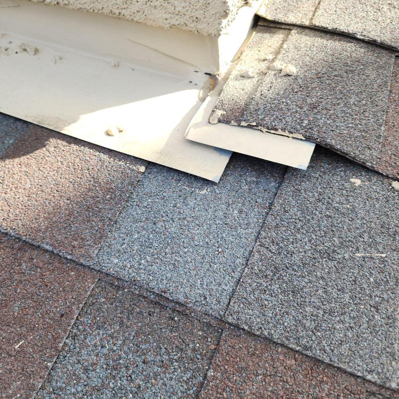 Shingle roof with damaged flashing near wall junction Shingle roof with damaged flashing near wall junction