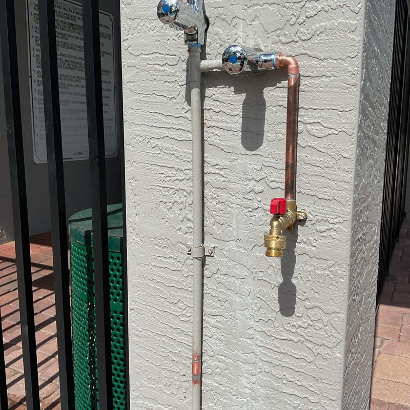 Copper hose bib with red valve and shower valves
