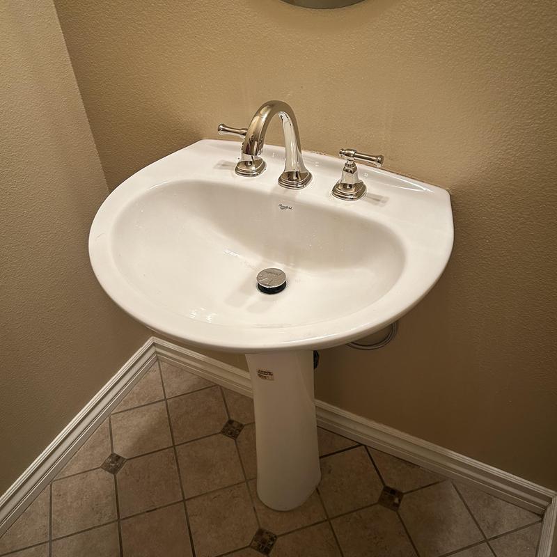 Wide spread faucet on pedestal sink installation