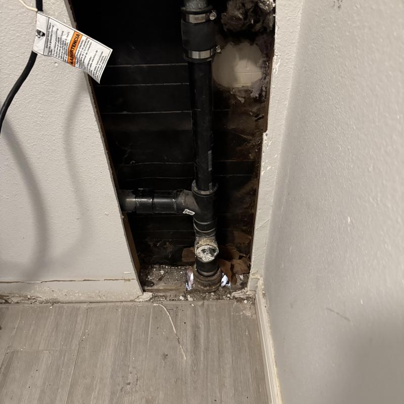 Black PVC drain pipe with wall opening and floor base