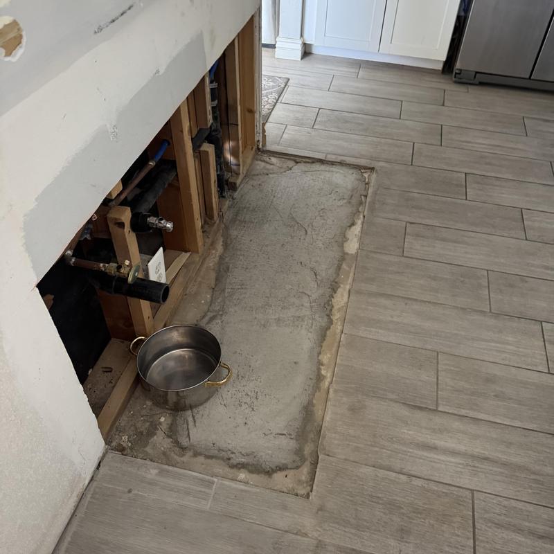 Kitchen water supply pipes exposed with concrete patch