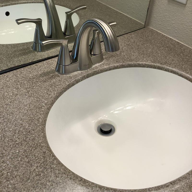 Bathroom sink faucet with silver handles and gray countertop