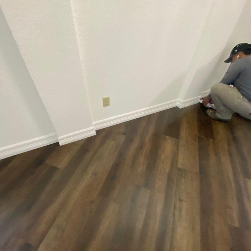 LVP flooring installation with new white baseboards