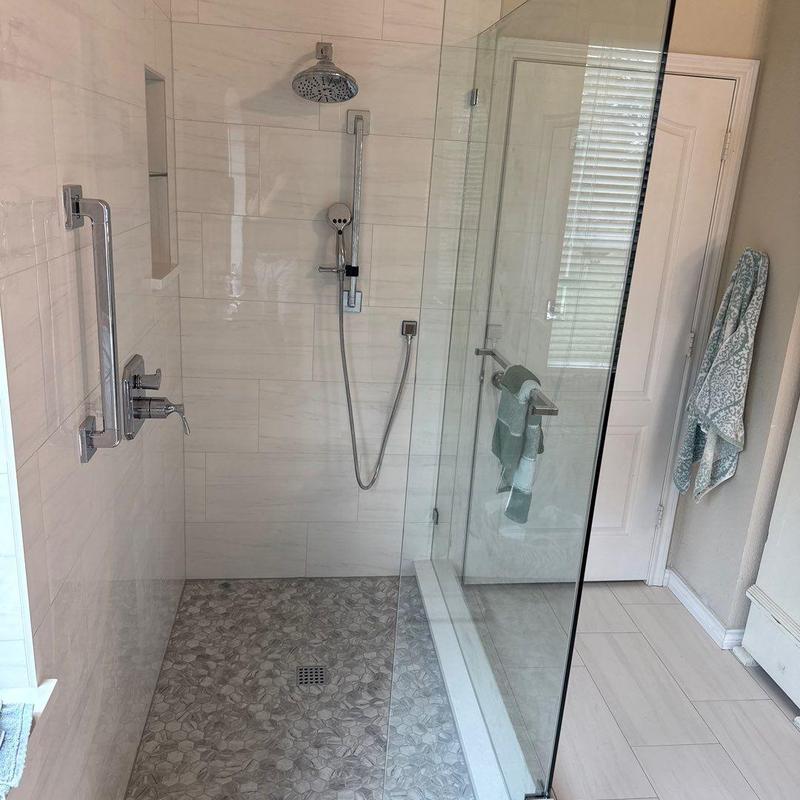 Open shower with frameless glass and tile floor Open shower with frameless glass and tile floor