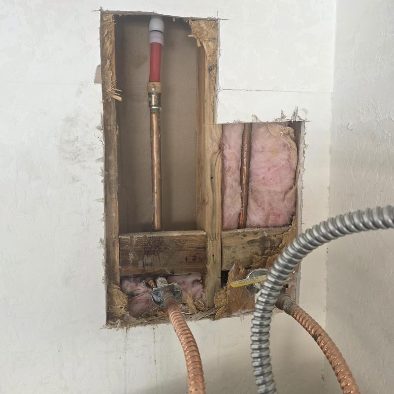 PEX piping and copper pipe exposed in wall cavity