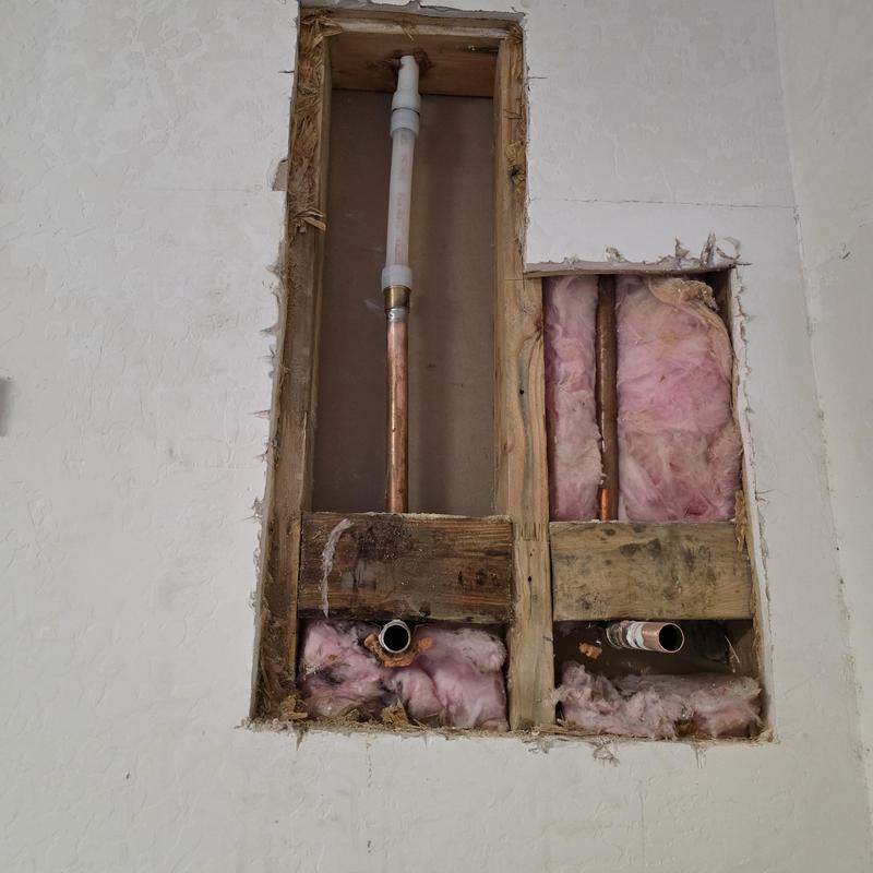 PEX pipe section exposed in wall with insulation