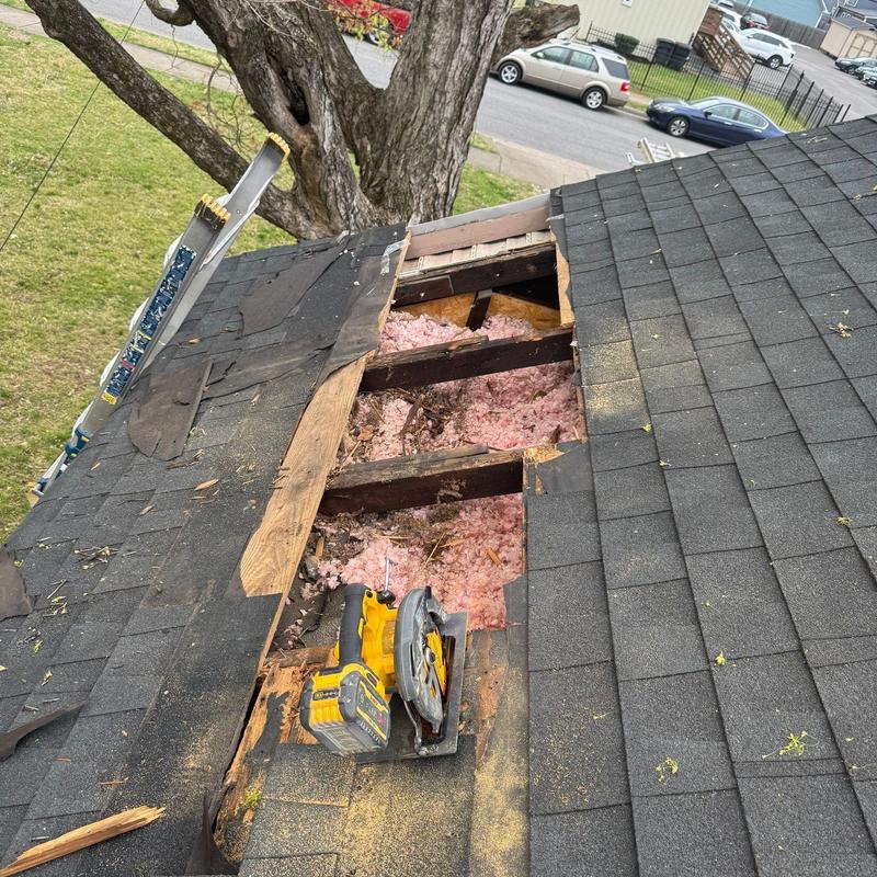 Asphalt shingles roof with removed damaged sections and tools