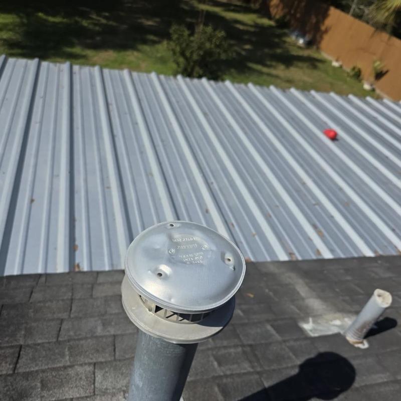 Metal vent cap on asphalt shingle roof inspection