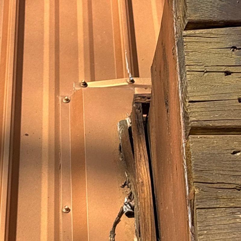Metal roof panel with wood trim damage