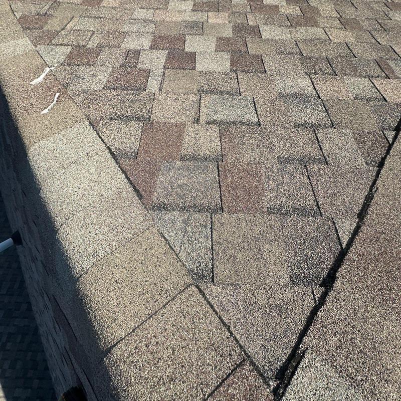 Asphalt shingle roof with hail damage and ridge caps