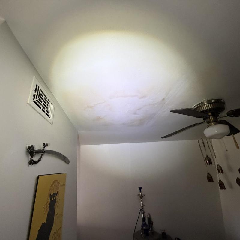 Ceiling with interior water damage stains near fan