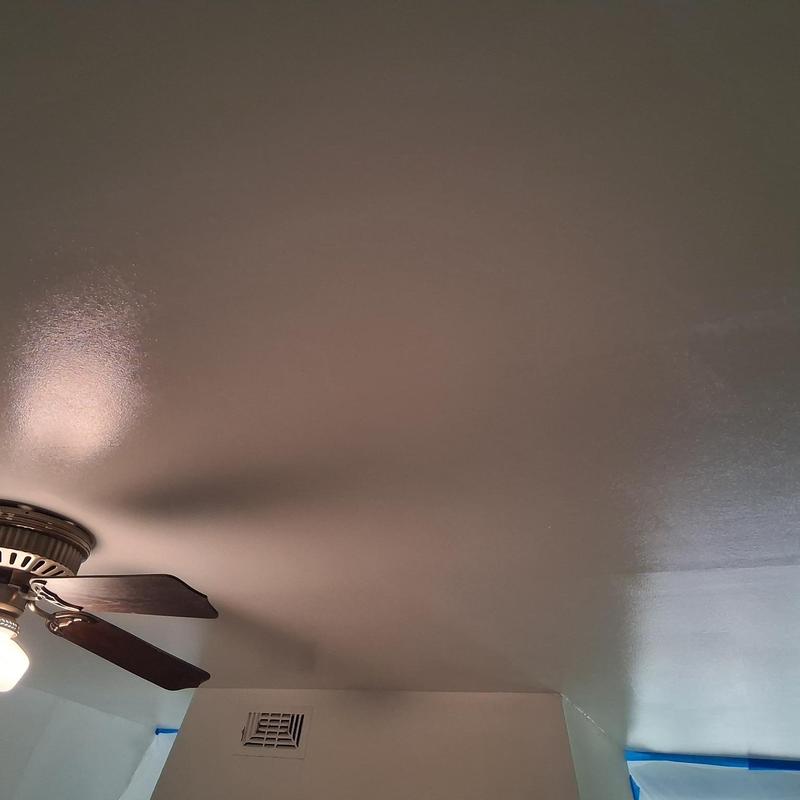 Ceiling with painted water damage and ceiling fan