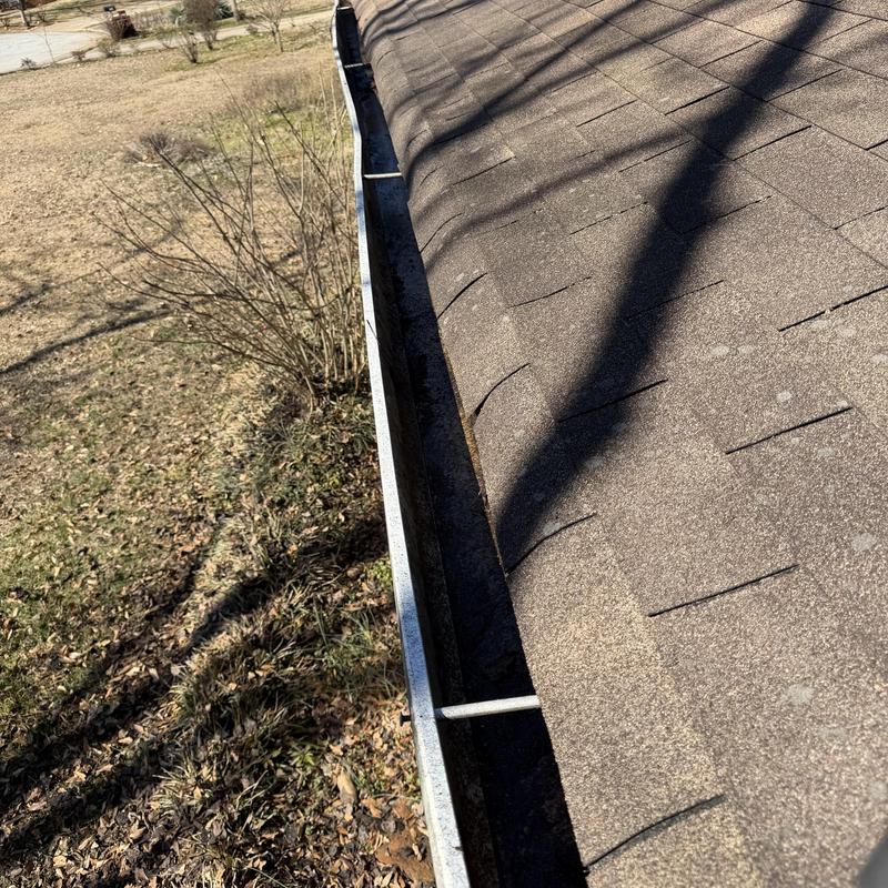 Gutter system cleaned along asphalt shingle roof