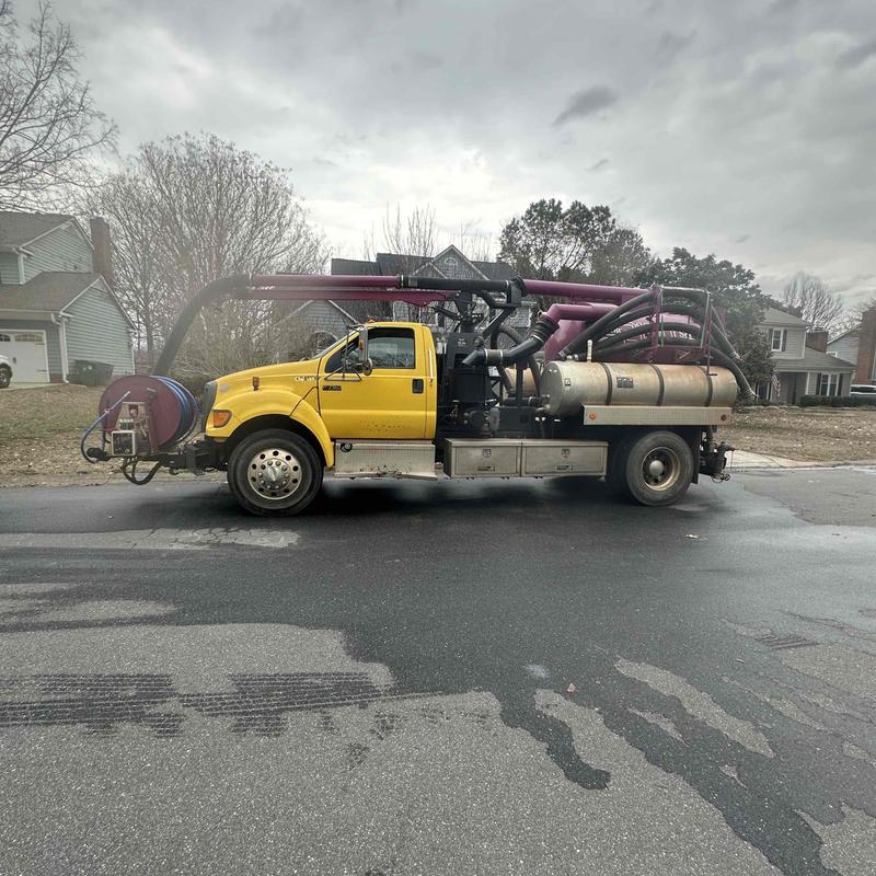 Vacuum truck with hose reels on residential street Vacuum truck with hose reels on residential street