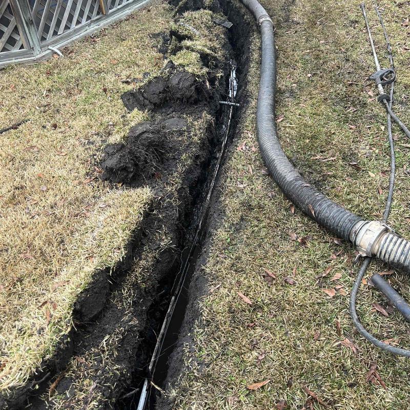 Underground drainage pipe with vacuum hose in trench Underground drainage pipe with vacuum hose in trench