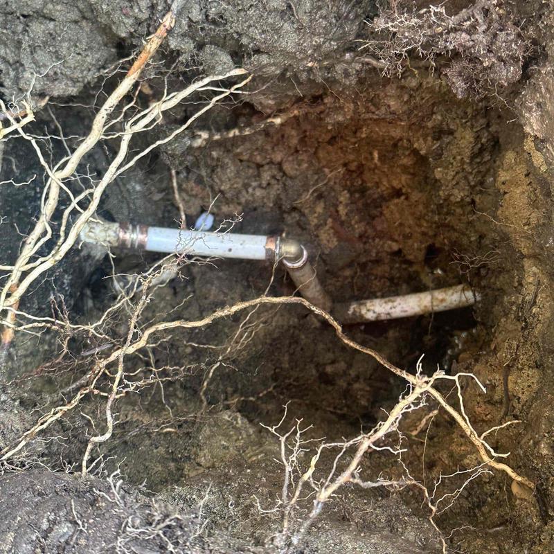 Underground plumbing pipes exposed in excavation hole Underground plumbing pipes exposed in excavation hole