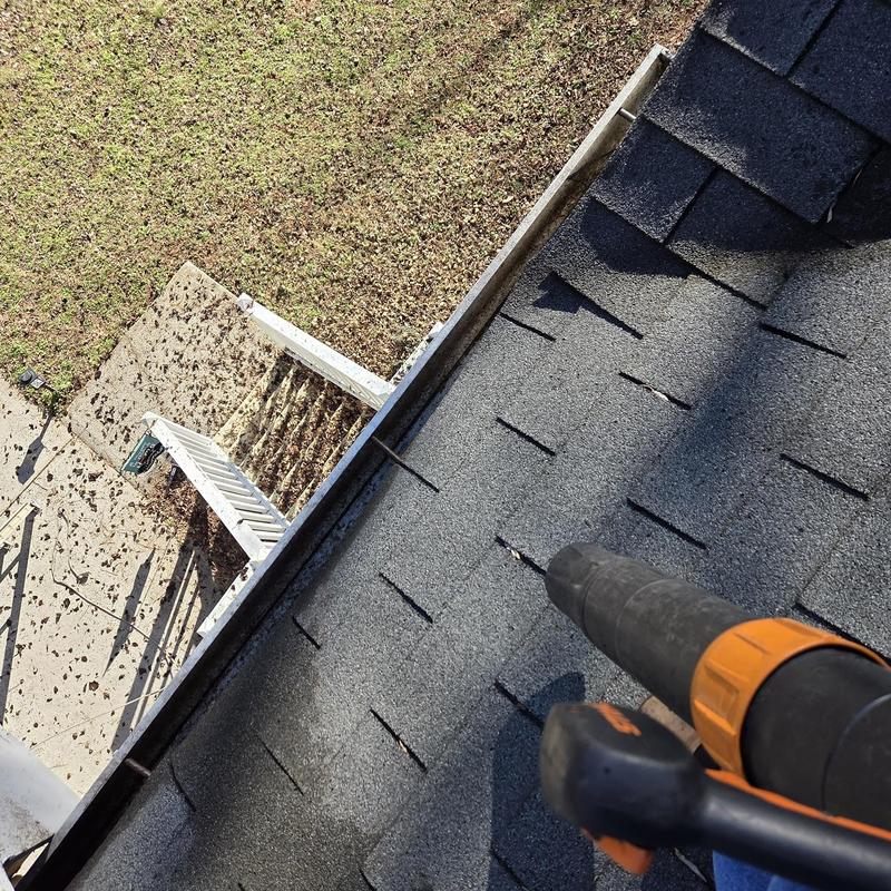 Gutter cleaning and debris removal on asphalt roof