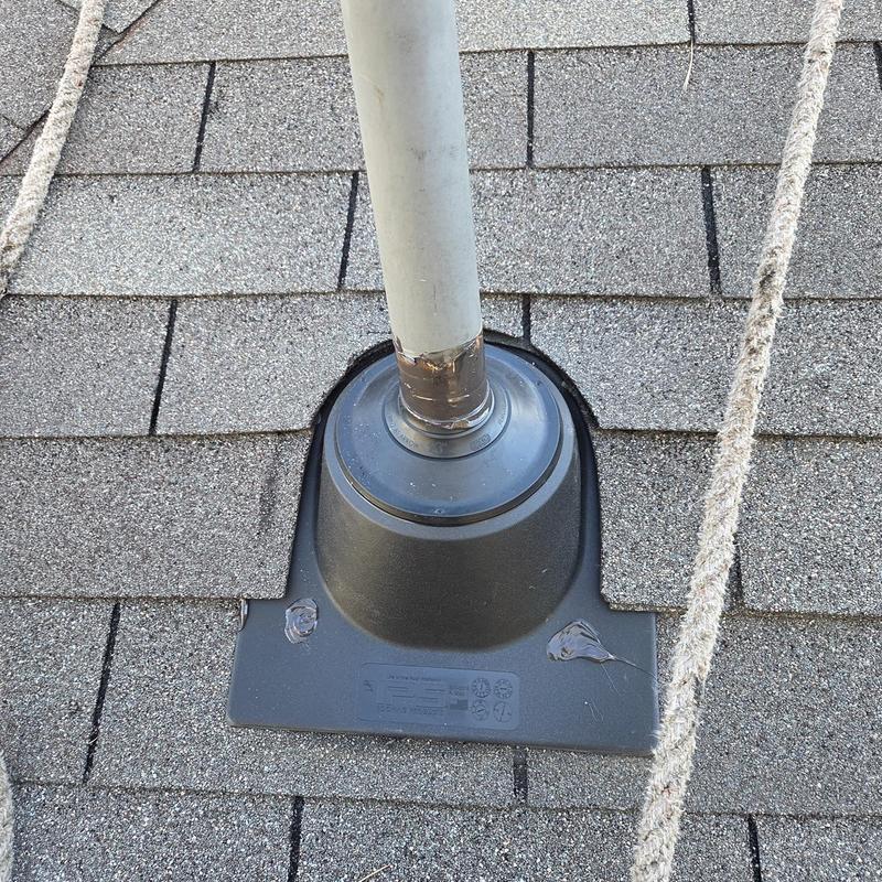 Pipe boot on shingled roof with caulking around edges