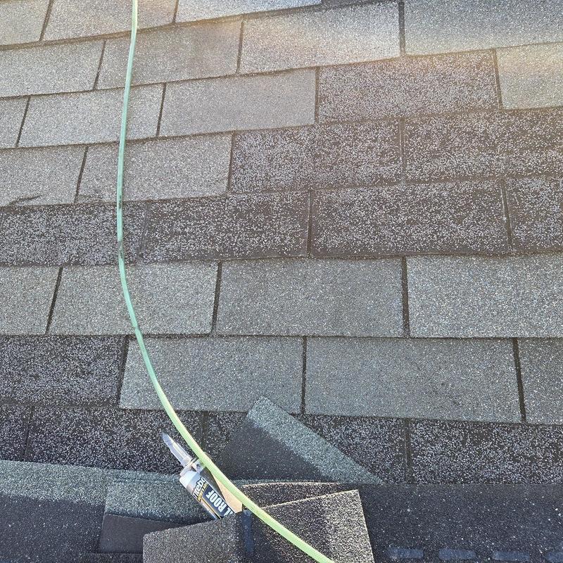 Roof shingles with ridge caps and caulk tube on roof