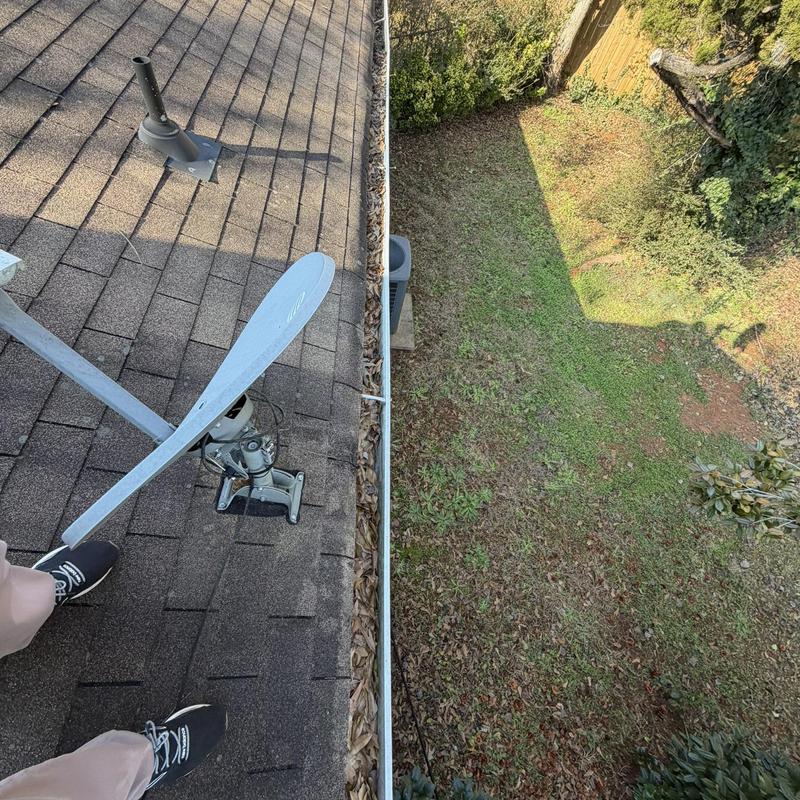 Gutter filled with leaves along roof edge