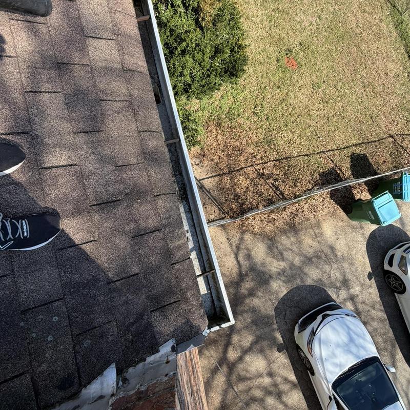 Gutter system cleaning on residential shingle roof