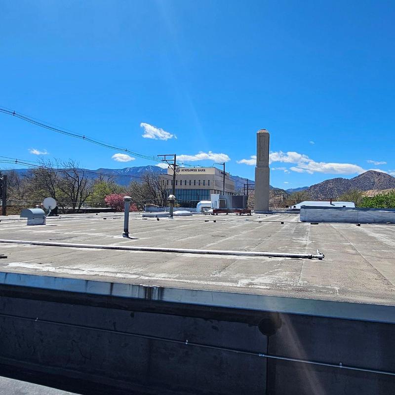 Modified bitumen roof flat surface with equipment and mountains Modified bitumen roof flat surface with equipment and mountains