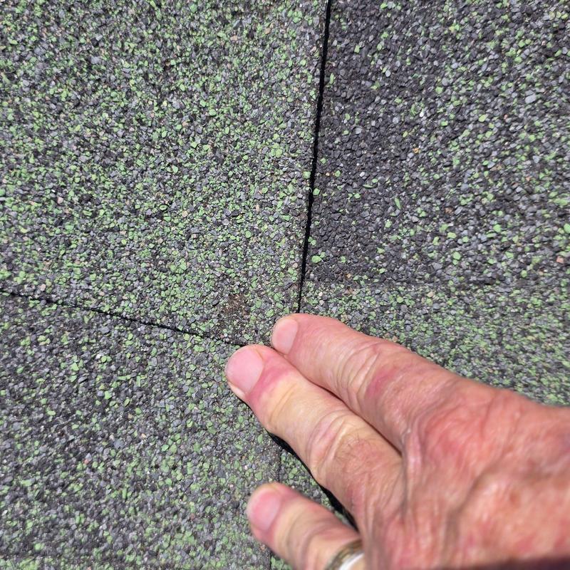 Roof shingles close-up with hail damage cracks