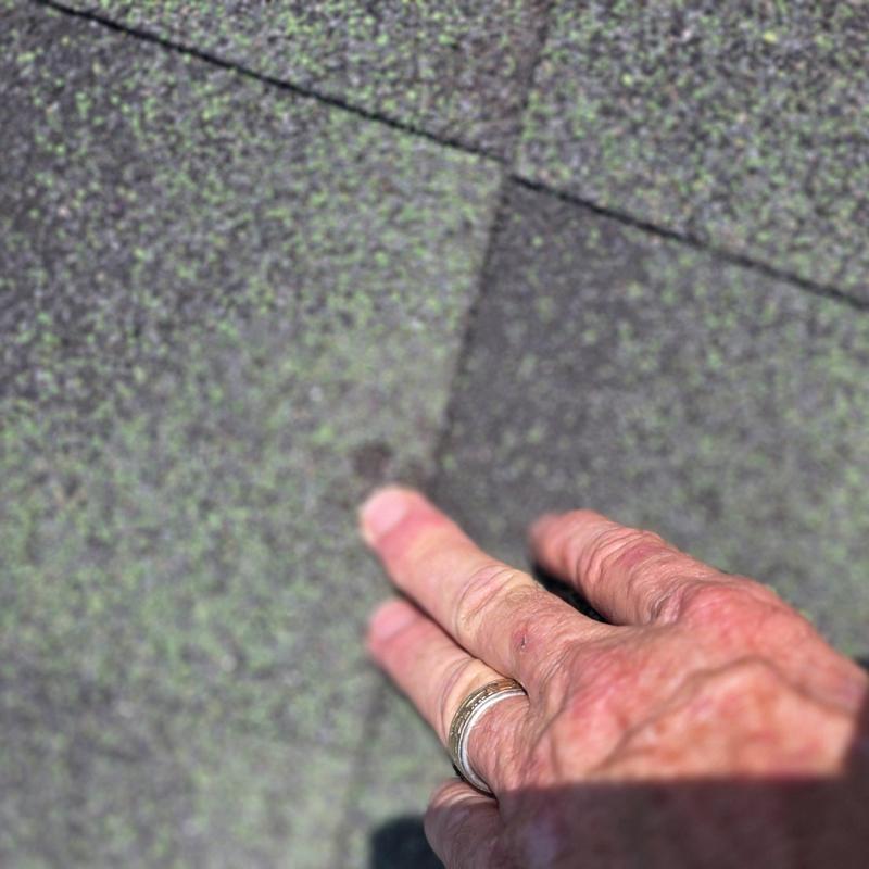 Asphalt roof shingles with hail damage close-up