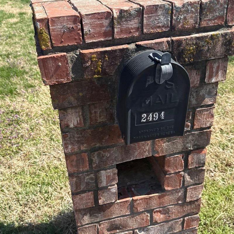 Brick mailbox with black curbside mail slot