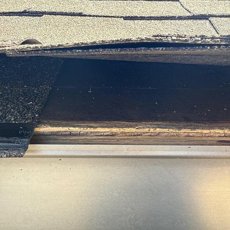 Roof shingle layers lifted revealing damaged underlayment