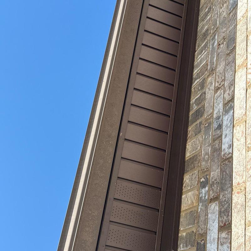 Roof soffit and brick wall junction under clear sky