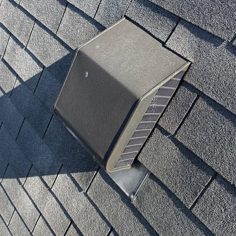 Roof vent on shingle roof with hail damage visible