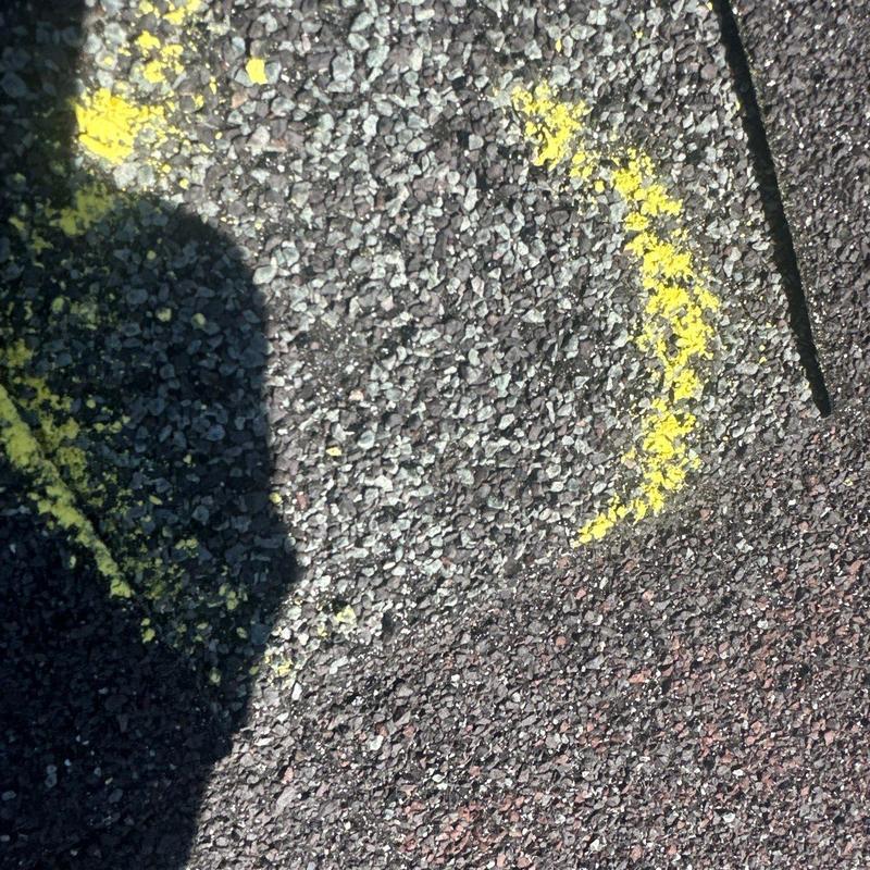 Roof shingles with yellow chalk marking hail damage