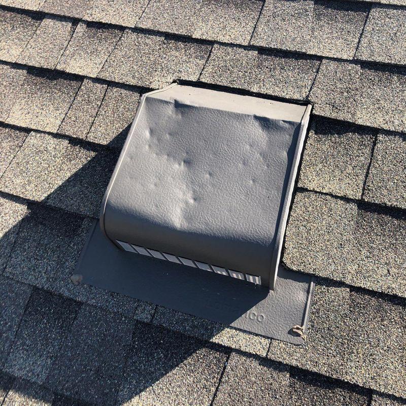 Metal roof vent with hail damage on shingles