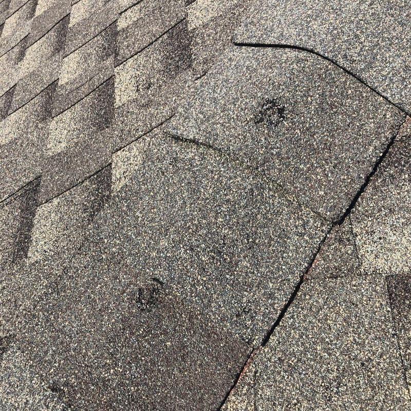Asphalt roof shingles with hail damage close-up