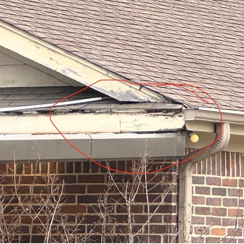 Fascia board rotting and gutter damage near roof edge