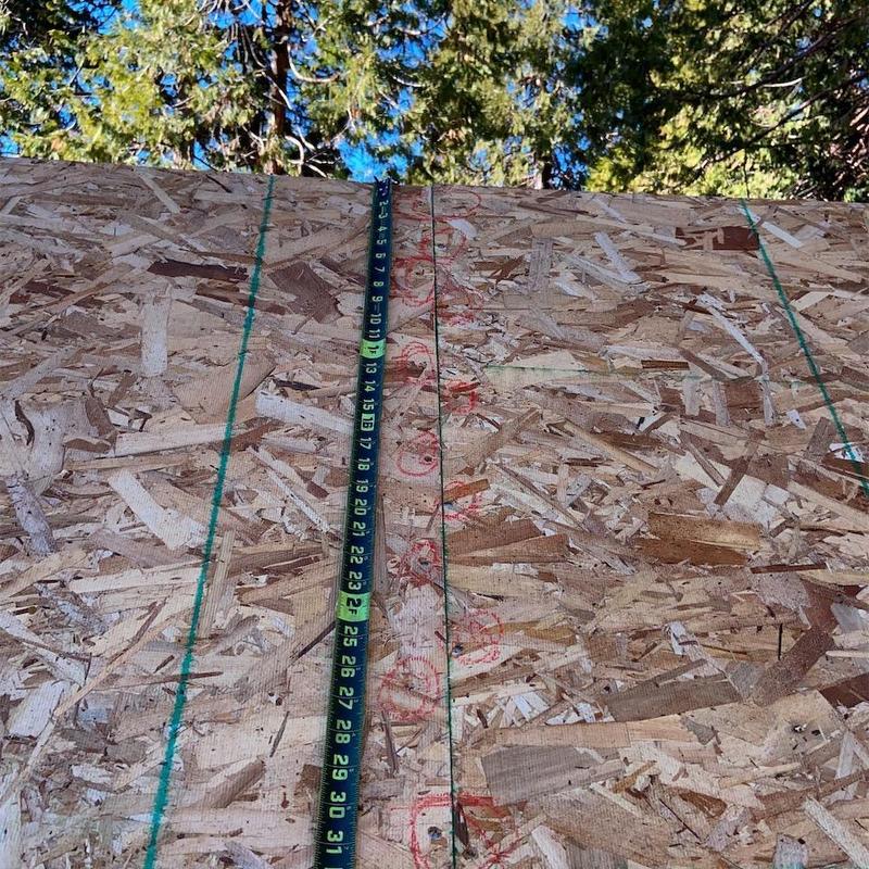 OSB roof sheeting installation with measuring tape