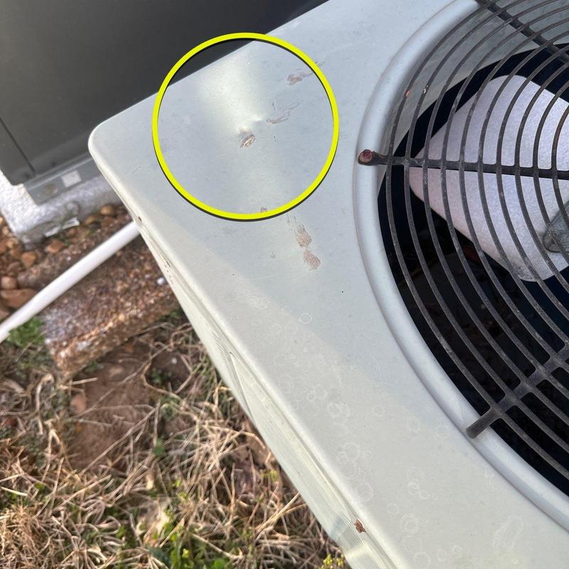 Air conditioner unit with hail impact dents on casing