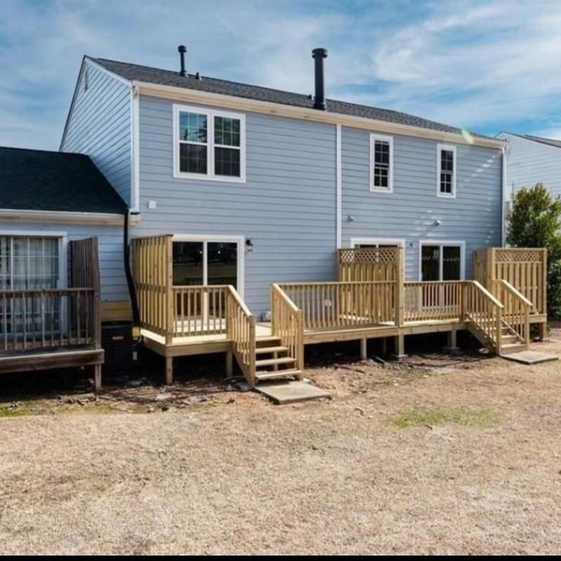 Wooden rear decks with stairs on townhouse exterior Wooden rear decks with stairs on townhouse exterior