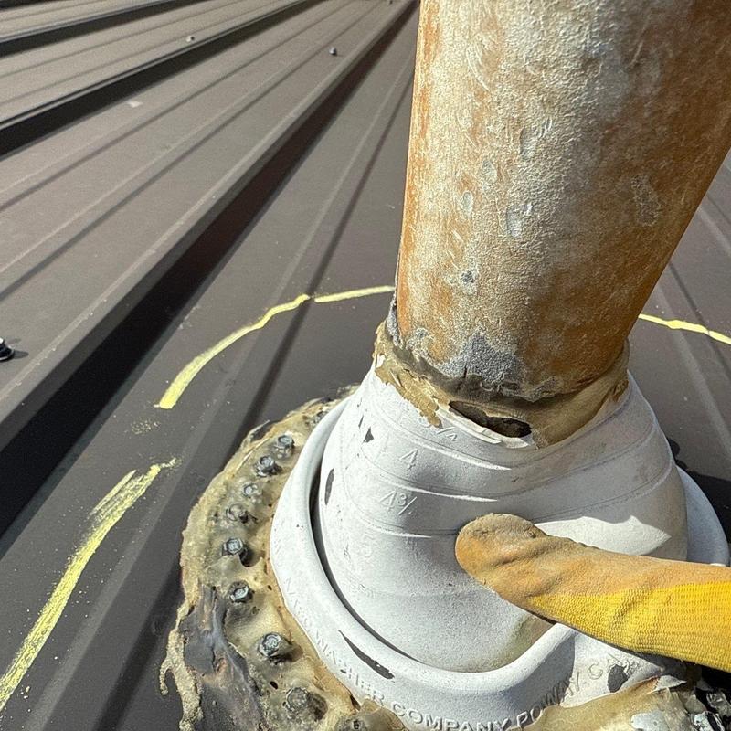 Metal pipe flashing on roof with visible damage