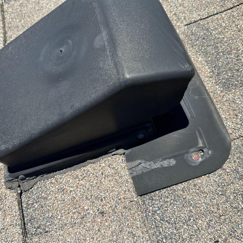 Roof vent flashing with sealant and shingle damage