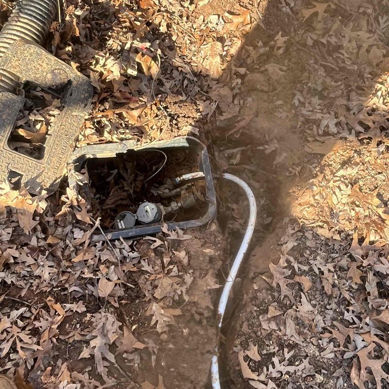 Outdoor water meter box with exposed pipes and wiring Outdoor water meter box with exposed pipes and wiring