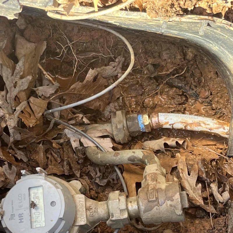 Outdoor water meter and piping with wiring exposed Outdoor water meter and piping with wiring exposed