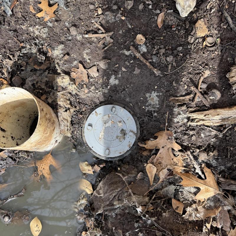 Sewer main cleanout with standing water and debris