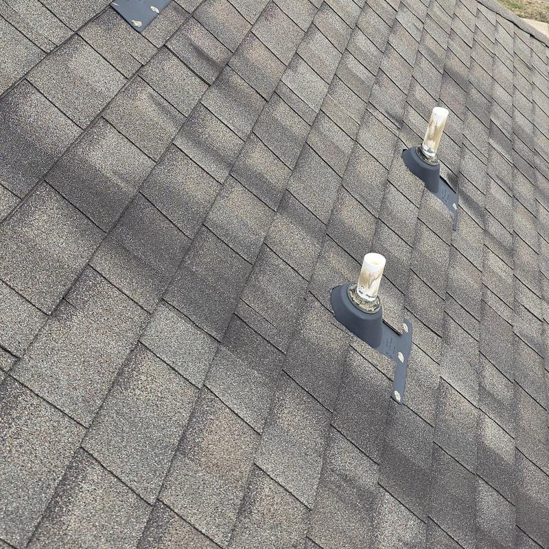Asphalt shingles with hail damage near vent pipes