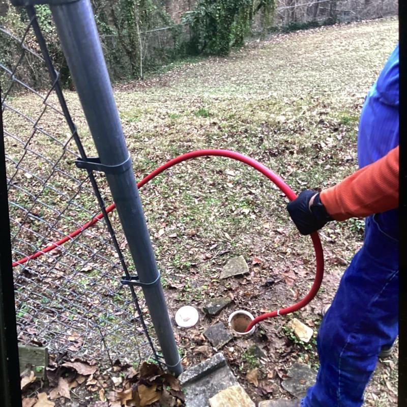 Sewer line hydro jet service with red hose outdoors