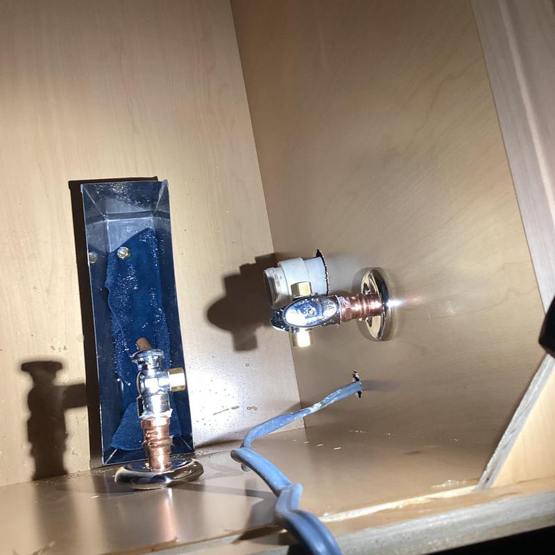 Sink shut off valves with copper piping inside cabinet