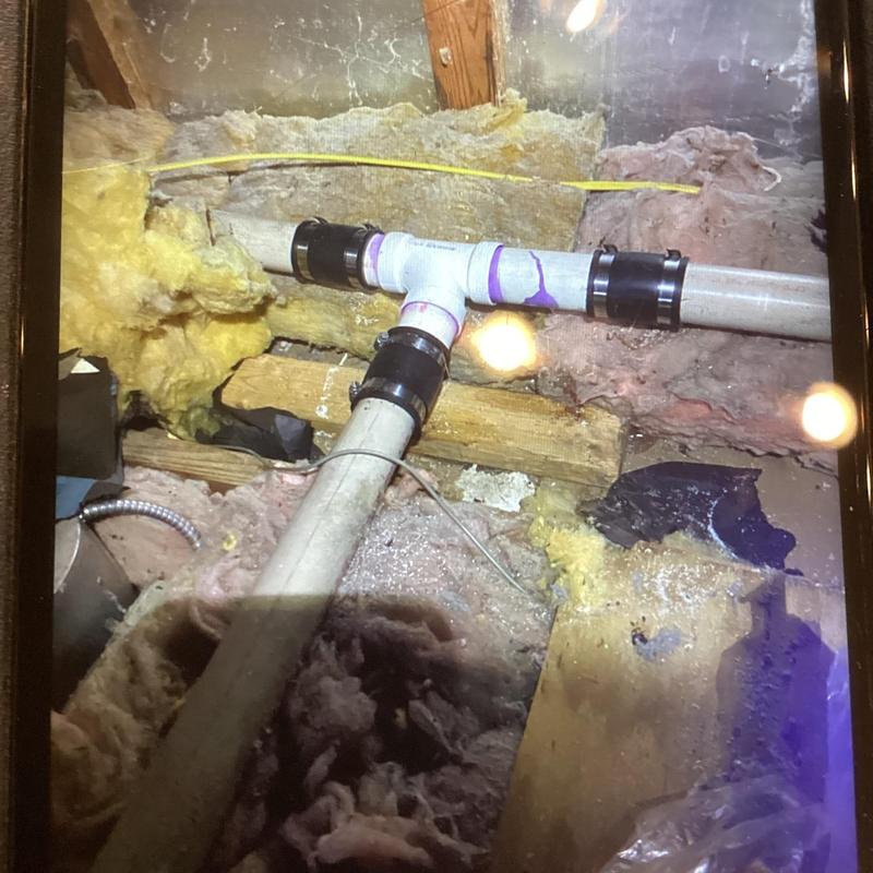 PVC vent tee piping installed in attic with insulation