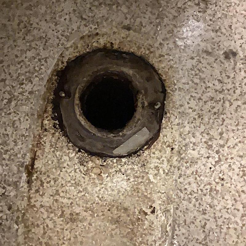 Toilet flange on bathroom floor with removed commode