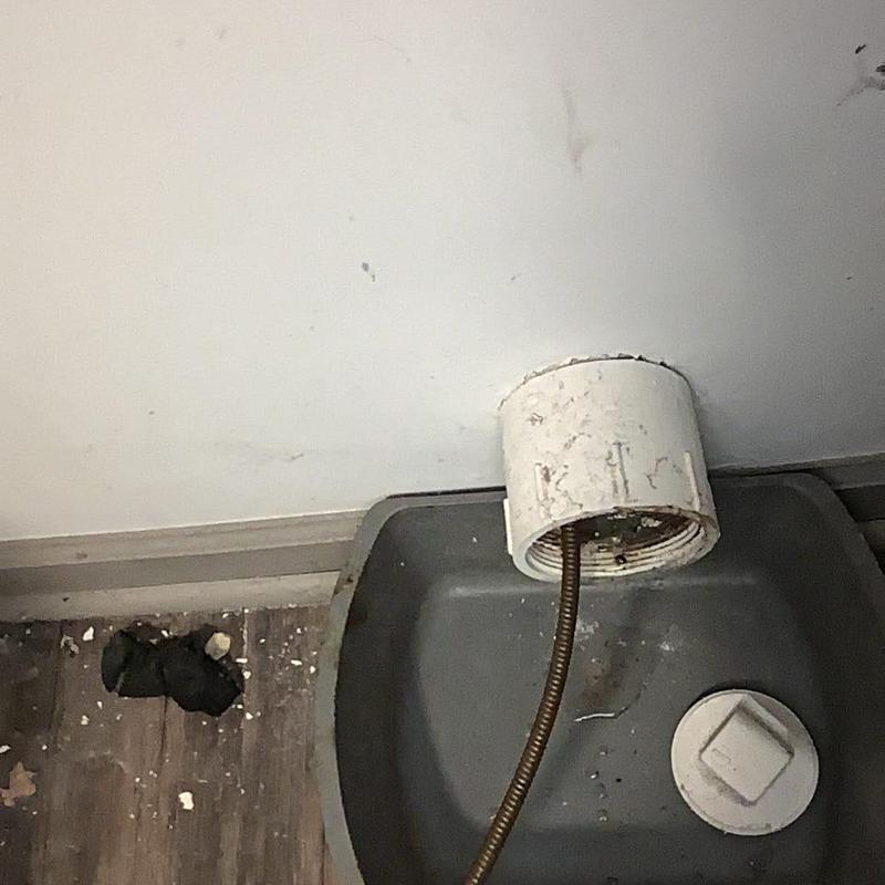 Washer drain pipe with plumbing snake cable inserted